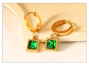 Détail macro de la boucle d'oreille zircon vert émeraude avec placage or texturé chic