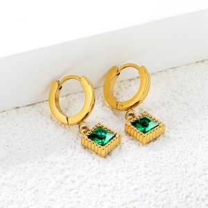 Élégantes boucles d'oreilles dorées avec pendentifs zircons émeraude sur présentoir
