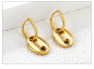 Vue macro de boucles d'oreilles dorées avec pendentif nez de cochon et fini poli miroir