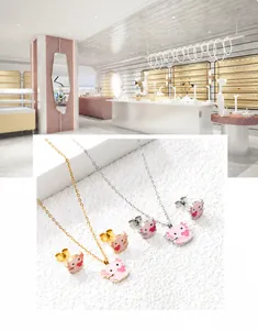 Gros plan sur l'ensemble collier et boucles d'oreilles axolotl en émail rose et acier