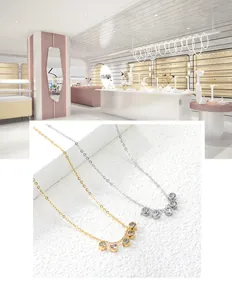 Dettaglio di collane in oro e argento con cinque pendenti in zircone su sfondo bianco
