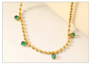 Detail of 18K gold stainless steel bead chain featuring four emerald green zircon pendants