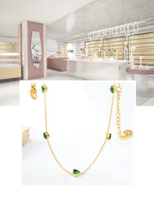 Detail of 18K gold chain necklace with five heart-cut emerald green zircons and lobster clasp