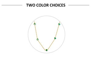 Detailed view of gold chain necklace with five heart-shaped emerald green gemstones