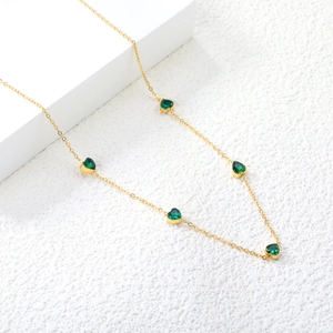 Elegant gold chain necklace featuring five heart-shaped emerald green zircon stones