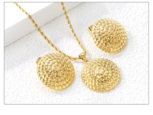 Macro detail of 18K gold-plated jewelry set with textured circular dome pattern