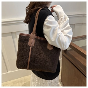 Detail of plush fleece tote bag with brown leather straps and soft woolly texture