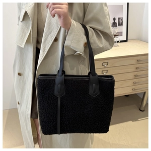 Détail du sac cabas noir en peluche imitation mouton avec poignée en cuir sur mannequin