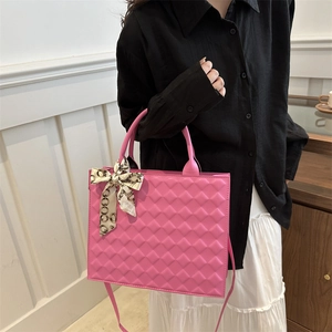 Magenta quilted tote bag with decorative silk scarf and adjustable strap, model shot