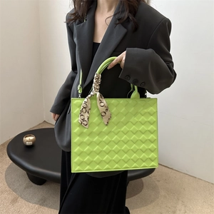Neon green quilted handbag with patterned silk scarf handle and slim shoulder strap