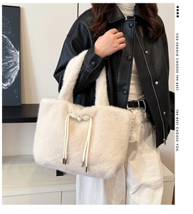 Dettaglio della borsa tote in peluche bianco panna con fiocco e morbida consistenza