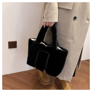 Dettaglio della borsa tote in peluche nera con nappe a coulisse e finiture in metallo dorato
