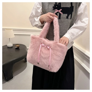 Dettaglio della borsa tote in peluche rosa con fiocco in raso mostrata in ambiente lifestyle