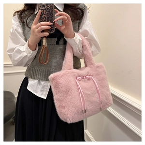 Dettaglio della borsa tote in ecopelliccia rosa con fiocco decorativo e punte in metallo