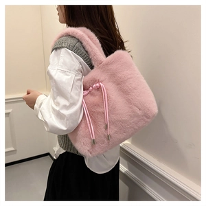 Dettaglio ravvicinato della borsa tote rosa in peluche con lacci in raso e fibbie in metallo