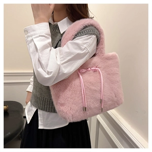 Dettaglio della borsa tote in ecopelliccia rosa con coulisse in raso e punte in metallo