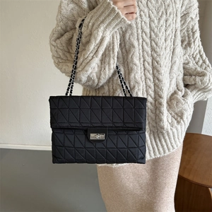 Black quilted crossbody bag with silver twist-lock and chain strap for autumn winter style