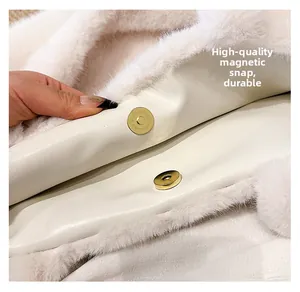 Dettaglio della chiusura magnetica dorata su una borsa tote in peluche bianca