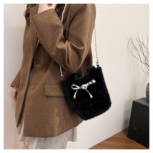 Détail du sac à main noir en fausse fourrure avec bandoulière en perles et nœud en soie