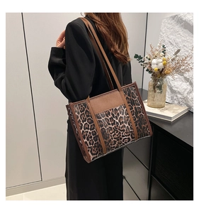 Détail du sac cabas léopard avec finitions en cuir marron et boucles métalliques