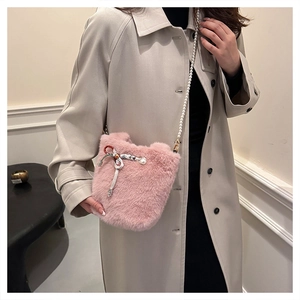 Sac seau en fausse fourrure rose avec nœud argenté, breloques perles et bandoulière perle