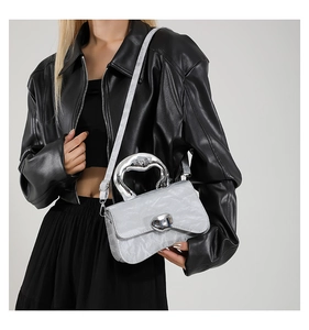 Silver textured handbag with unique metal handle styled with a chic leather jacket