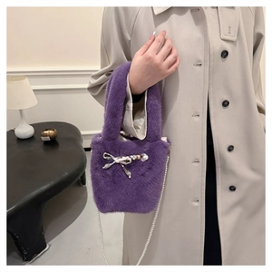 Détail du sac seau en fausse fourrure violette avec bandoulière en perles et nœud