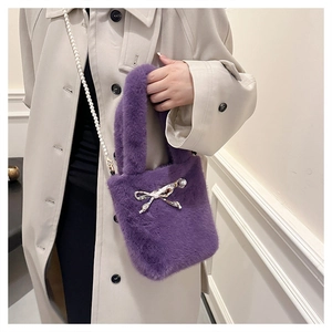 Détail du sac à main violet en fausse fourrure avec bandoulière perle et nœud élégant