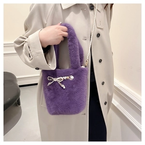Détail du sac seau en fausse fourrure violette avec bandoulière en perles et nœud