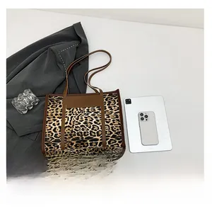 Detailed overhead view of leopard print tote bag with brown leather trim and thin straps