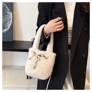 Détail du sac seau en fausse fourrure beige avec nœud en soie et bandoulière en perles