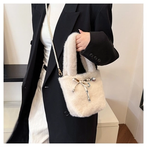 Détail du sac seau en fausse fourrure avec bandoulière perles et nœud en ruban