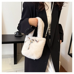 Détail du sac en fausse fourrure avec nœud en soie et bandoulière en perles