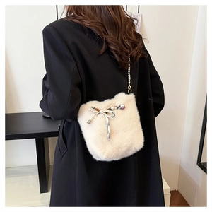 Détail du sac seau en fausse fourrure crème avec bandoulière perle et noeud