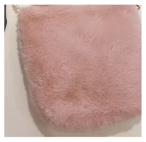Détail de la matière en fausse fourrure rose avec poignée en perles sur le sac