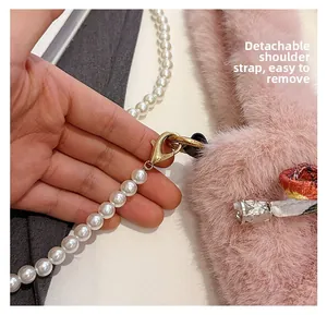 Détail de la bandoulière amovible en perles et fermoir métallique sur le sac en peluche