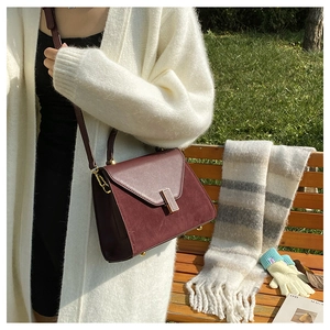 Close-up of burgundy Kelly bag featuring matte suede and smooth leather textures