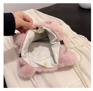 Détail de l'intérieur du sac en fausse fourrure rose avec fermoir magnétique et perles