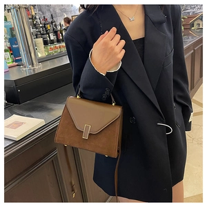 Detail shot of the two-tone brown leather and suede stitching with gold buckle on Kelly bag