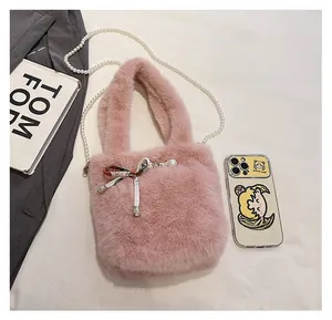 Détail du sac seau rose en fausse fourrure avec bandoulière perles et taille de téléphone