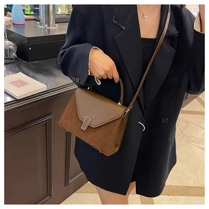 Close-up of brown textured Kelly bag with golden buckle and sleek leather stitching