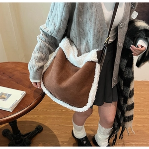 Detailed view of brown faux suede bag with white fleece trim worn by a model