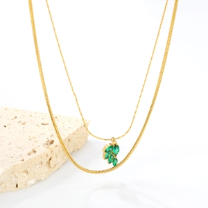 Double-layered gold necklace with green leaf zircon pendants on a sleek snake chain
