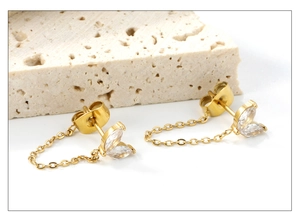 Detailed close-up of 18K gold-plated tassel earrings with leaf-shaped white zircons