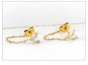 Macro detail of gold chain tassel earrings with marquise-cut cubic zirconia leaves