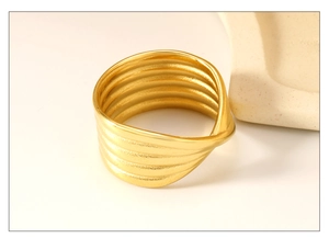 Macro detail of 18K gold-plated stainless steel ring with twisted multilayer ribbed texture
