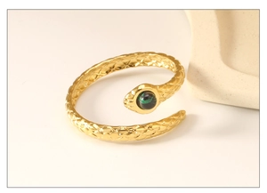 Macro view of gold snake ring with green stone inlay and textured scale details
