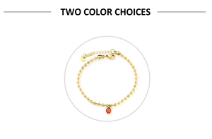 Détail du bracelet à perles dorées avec pendentif coccinelle et étiquette en acier