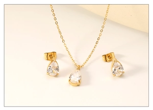 Detail of pear-cut white zircon jewelry set with gold necklace and matching stud earrings