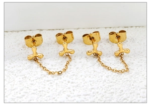 Detailed view of gold chain earrings with clover studs in polished stainless steel
